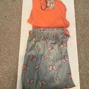 The pants it has pink and purple butterflies,on the shirt it, it says dream big.